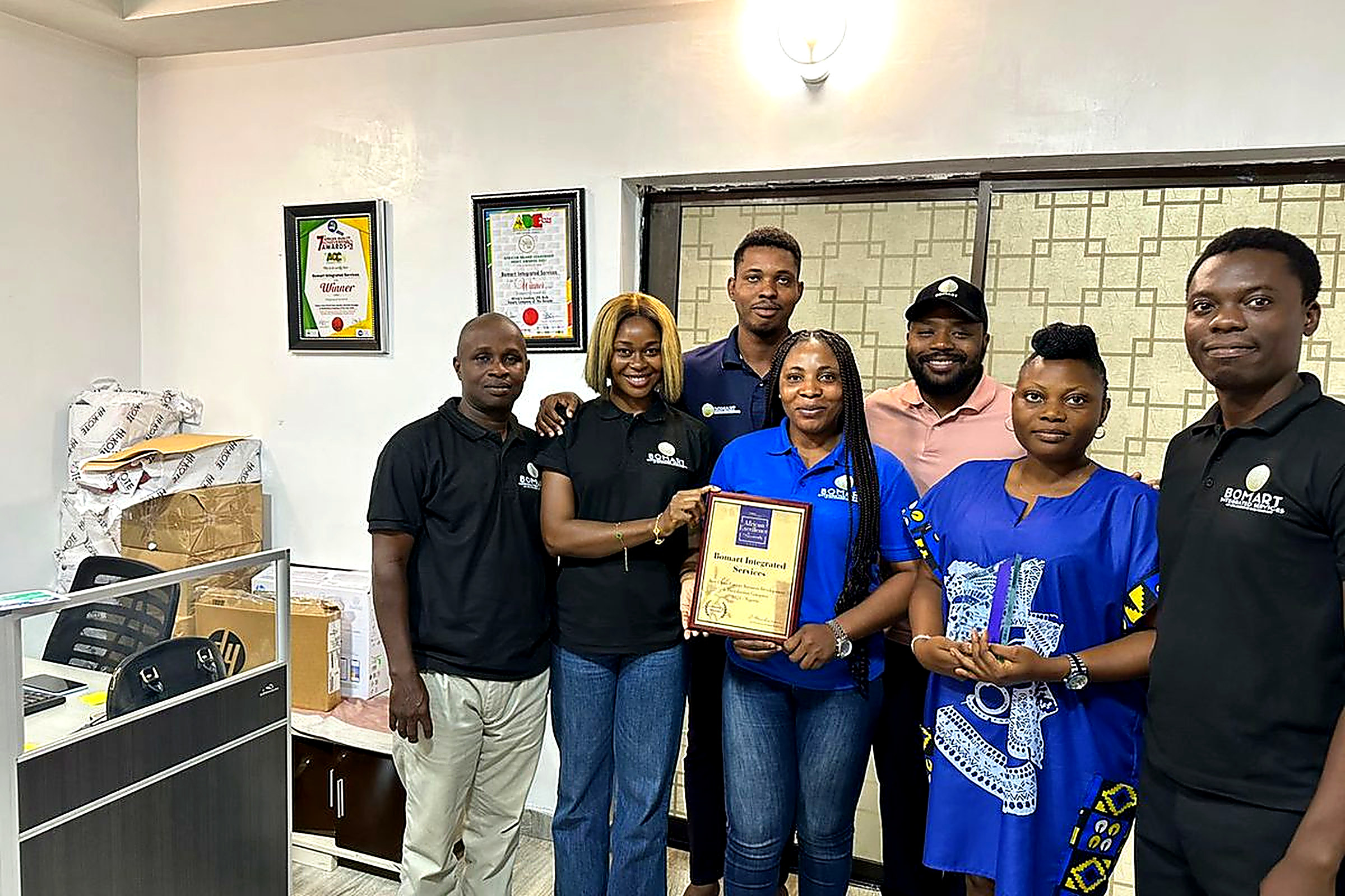 The Bomart Integrated Services team in Lekki HQ holding the AQAA operational excellence award plaque